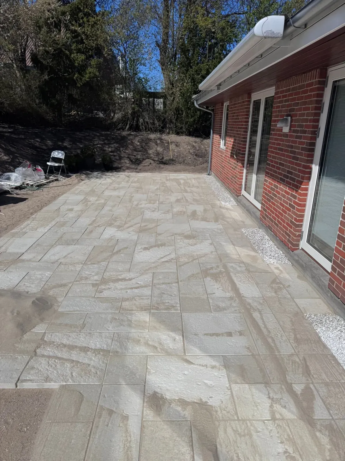 Terrasse i sandsten lagt op ad huset