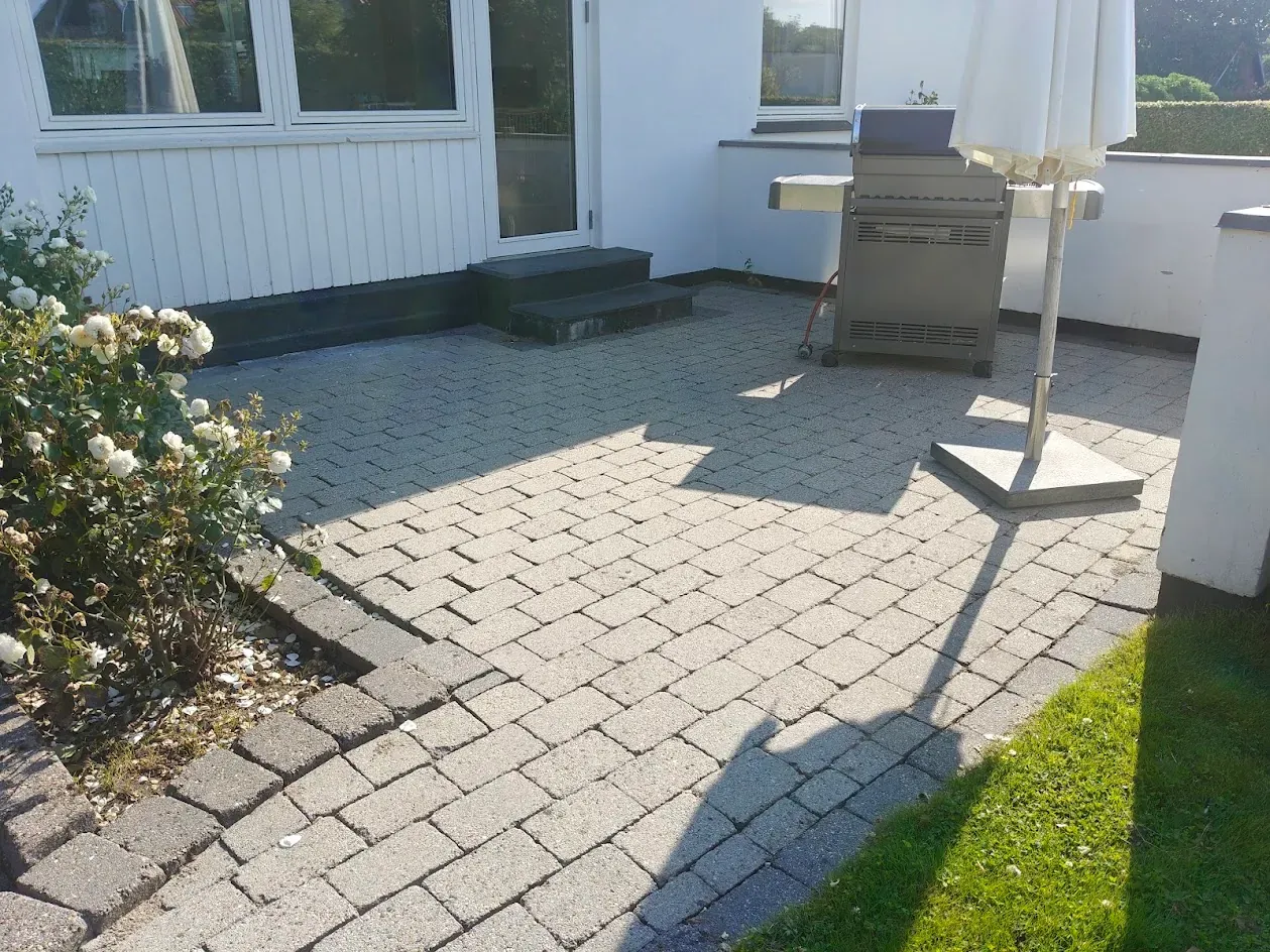 Samme terrasse efter fliserens – fugerne er rene og belægningen lys igen