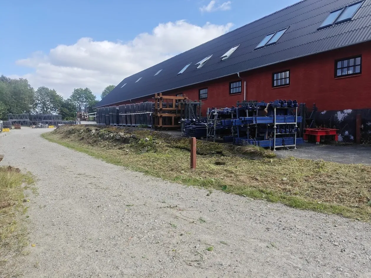 Ryddet skråning langs bygningen — bevoksningen skåret ned i bund